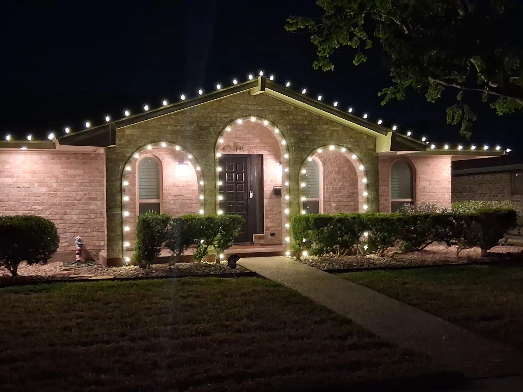 Single-story brick home with precise warm white C9 roofline lighting